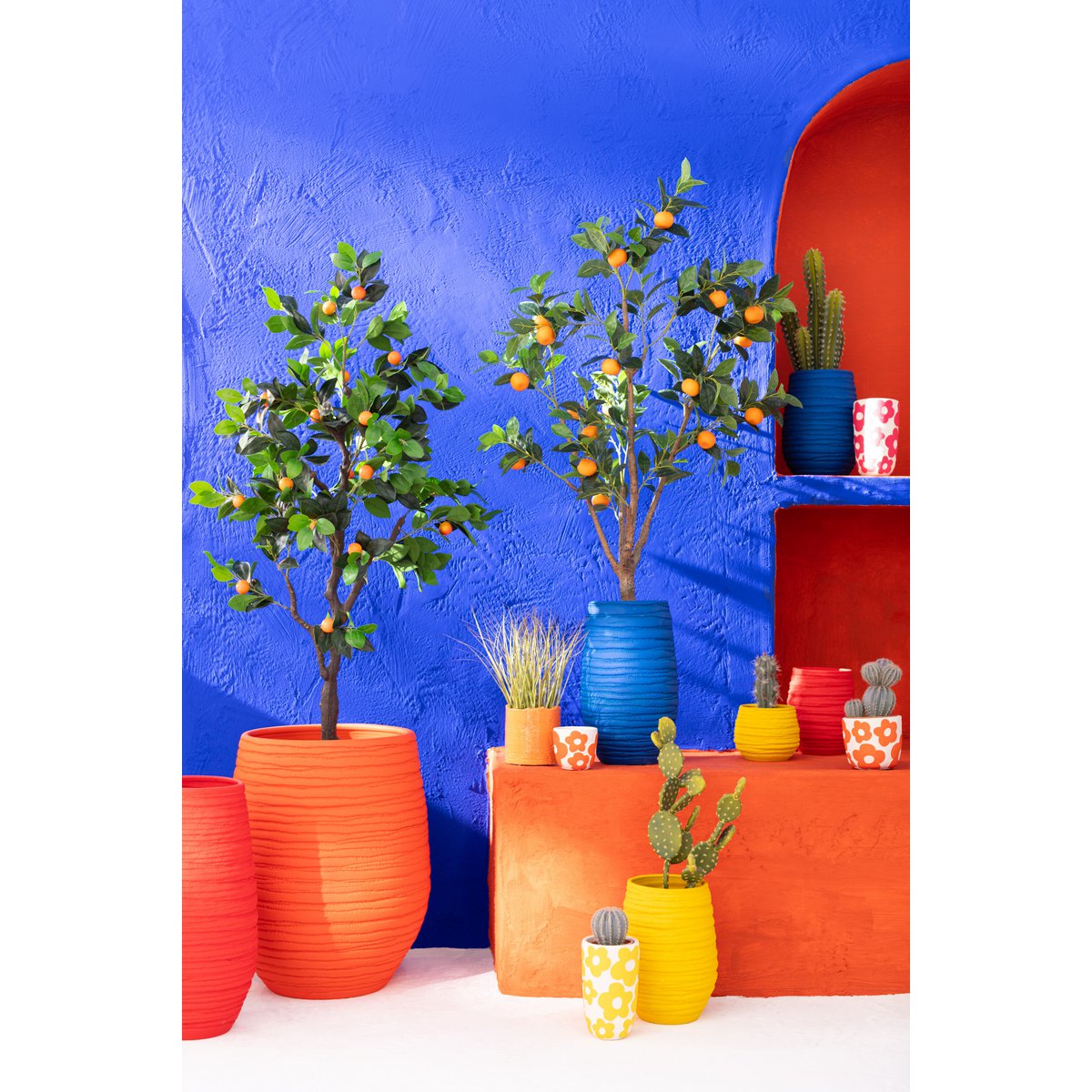 Levensechte kunststof sinaasappelboom van J-Line, 130 cm hoog, met oranje vruchten en groene bladeren in een stijlvolle pot, ideaal als blikvanger in huis of kantoor