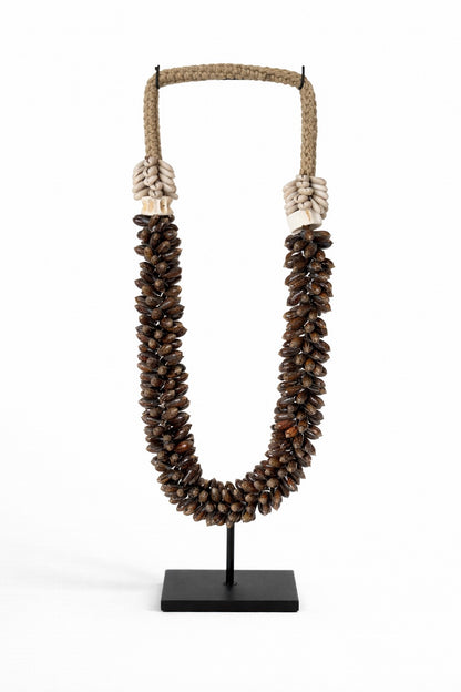 Handgemaakte schelpenketting op standaard met donkerbruine natuurlijke schelpen van Pole to Pole – decoratief woonaccessoire met wereldse uitstraling